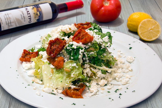 Kastro Oia Restaurant Santorini. Rocket with boiled wheat, escarole, lettuce, sun dried tomatoes, spearmint, unsalted white cheese and balsamic honey vinegar sauce.