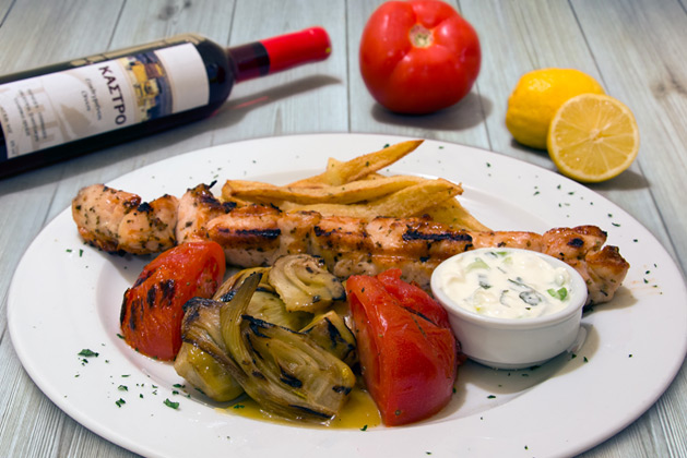 Kastro Oia Restaurant Santorini. Chicken Souvlaki with fries, grilled tomato and yoghurt sauce.